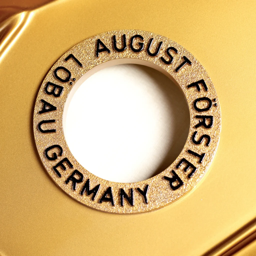 August Förster Emblem auf einem Klavier Gussrahmen
